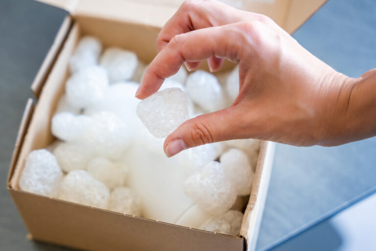 Eco packaging of parcels and white biodegradable filler. Box is filled with a filler safety for environment